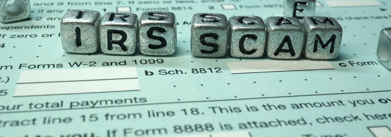tax paperwork with beads scattered on top that spell out irs scam