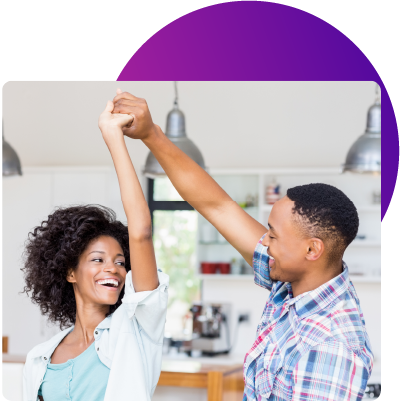 a young couple dancing in their new home thanks to a great low interest rate from their Wellby adjustable-rate mortgage