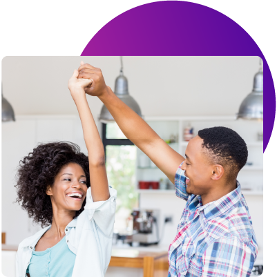 a young couple dancing in their new home thanks to a great low interest rate from their Wellby adjustable-rate mortgage